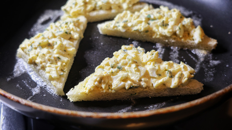 egg toasts cooking in a buttery skillet