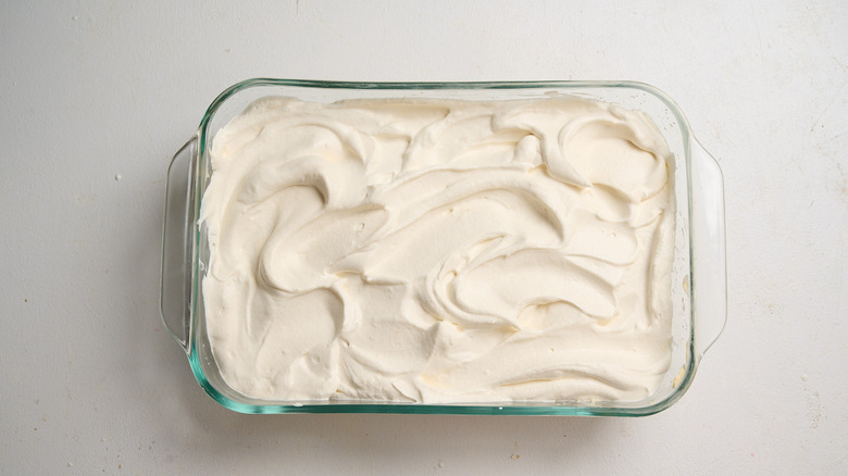 whipped cream spread on top of pudding mixture in dish