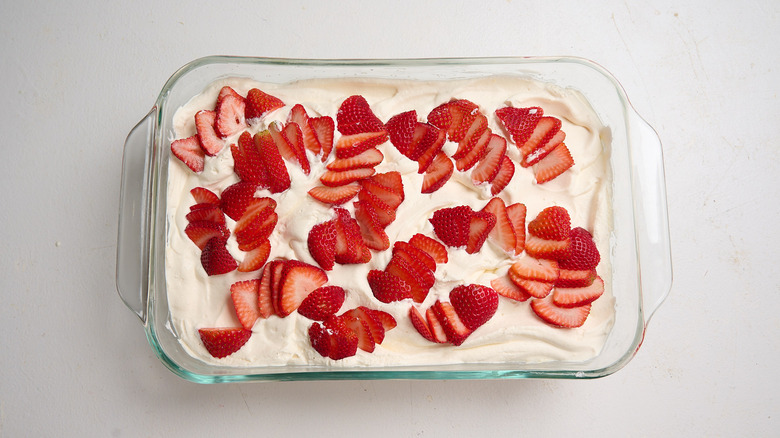 sliced strawberries on top of cake