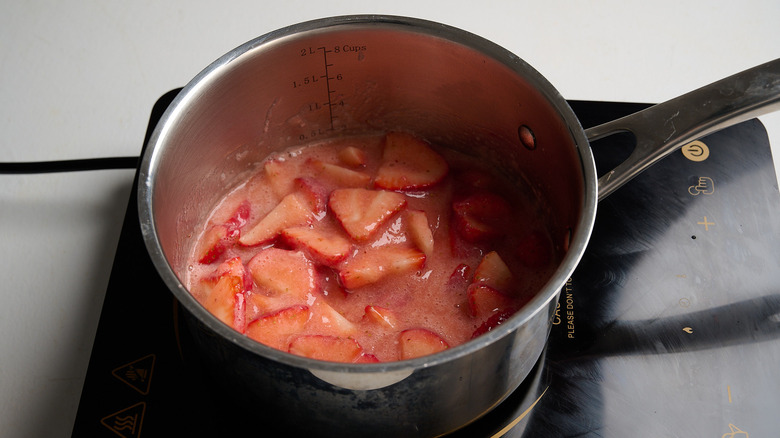 Sliced strawberries cooking in a saucepan