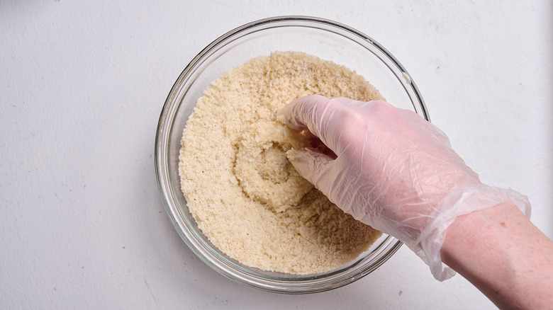 pressing onions into breadcrumb mixture