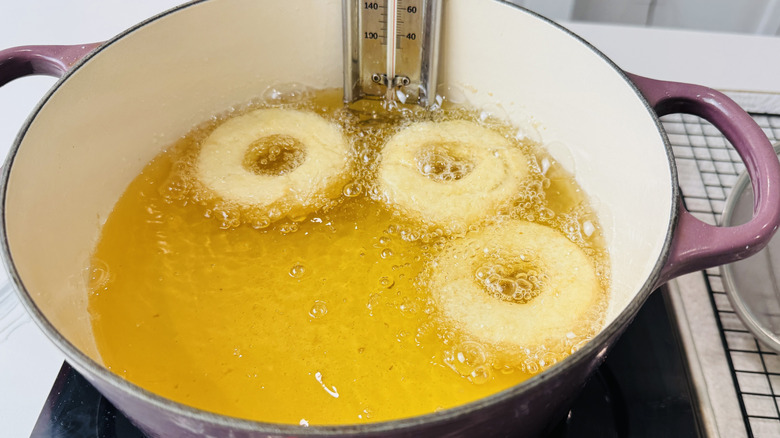 Old-fashioned doughnuts frying in pot