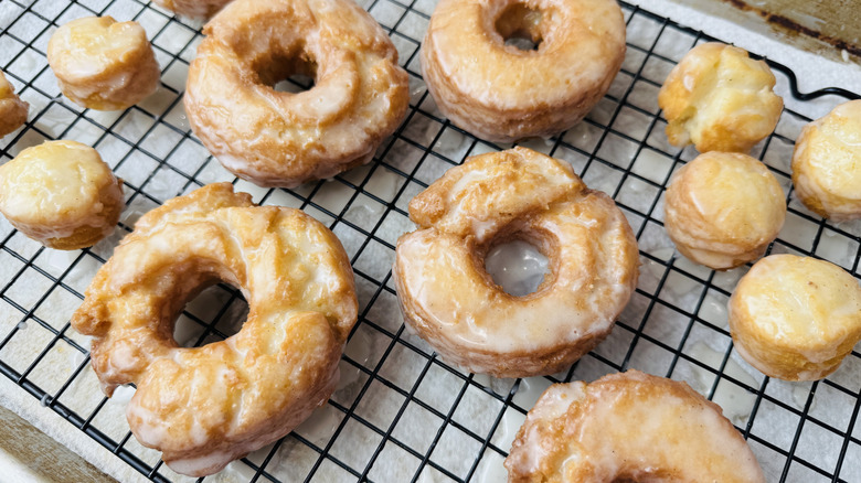 Glazed and cooling old-fashioned doughnuts on rack