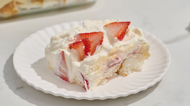 Slice of creamy cake with strawberries on plate