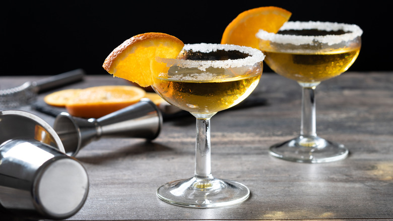two sidecar cocktails with sugar rims and orange slice garnishes