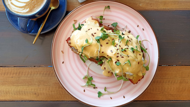 Top-down view of eggs Benedict on pink plate
