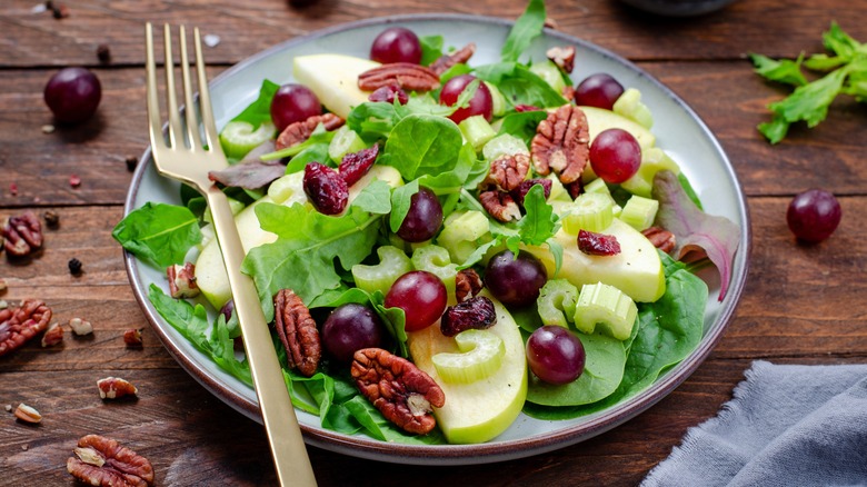 Plate with Waldorf salad on wooden table