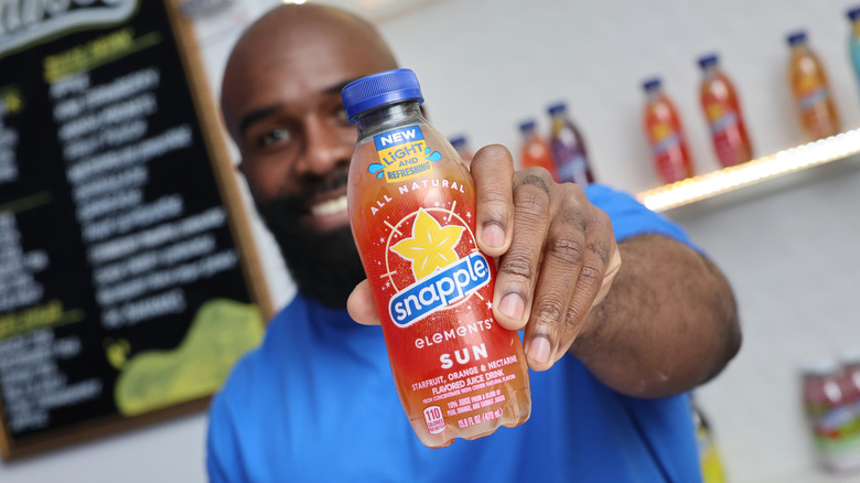 A person holding Snapple Elements drink