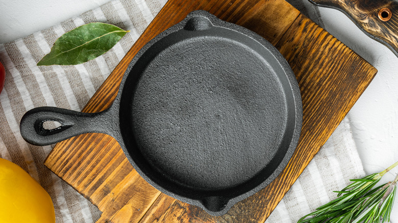 clean and empty cast iron skillet on wooden board