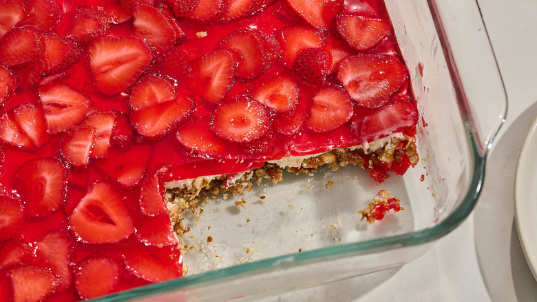 strawberry pretzel salad in a serving dish with a piece removed