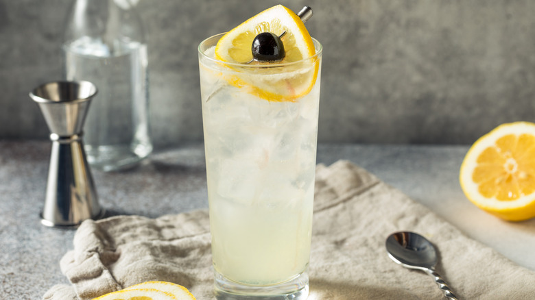 Tom Collins cocktail with lemons, bar tools