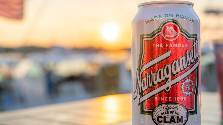 Can of Narragansett beer with a blurred sunset in the background