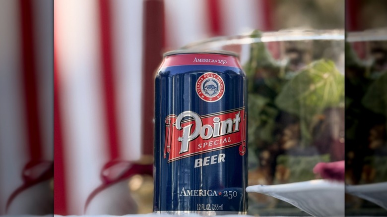 Mirrored image of a Fourth of July-themed can of Point beer in front of a blurred flag