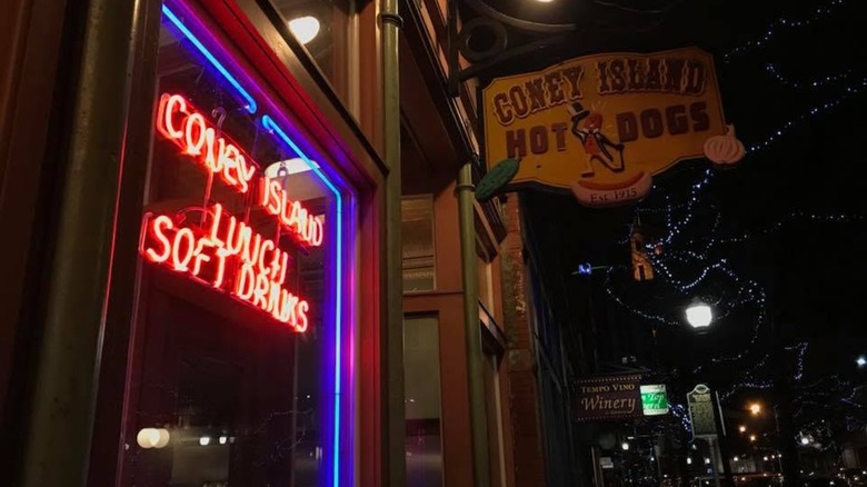 Exterior of Coney Island Hhot Dogs at night with neon lights