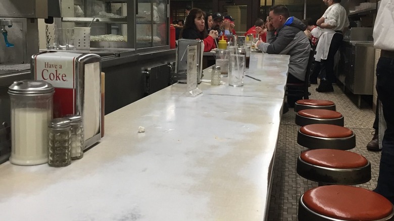 Worn counter with red stools