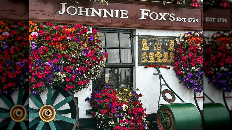 Exterior of Johnnie Fox's with flowers, a window, and a memorial plaque