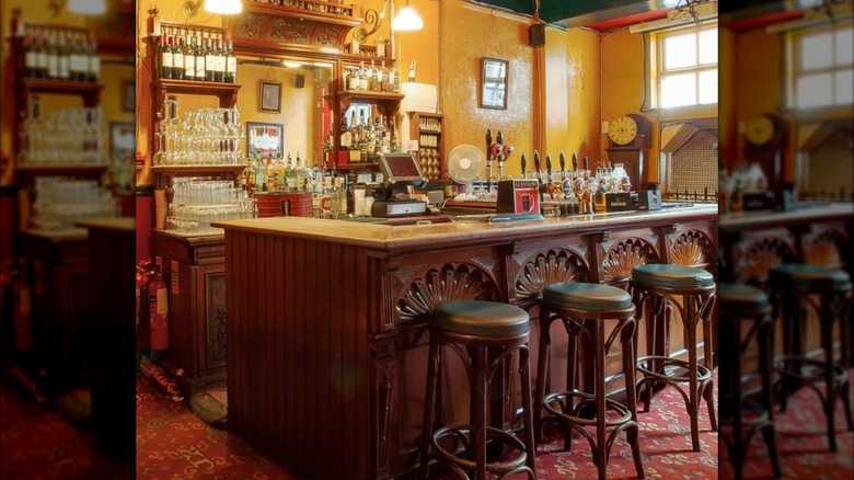 Ornate bar with stools, taps, glassware, and bottles in Kehoes