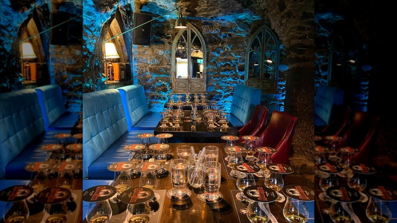 Tables set for a tasting with glasses, plus a medieval wall in the background, at Kyteler's Inn