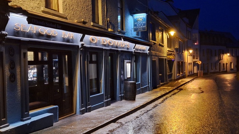 Exterior of O'Dowd's at night with a wet street