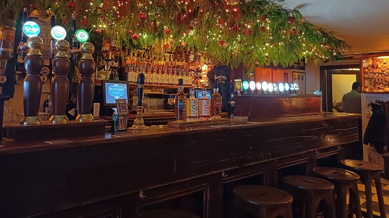 Bar and stools with taps and hanging lights with decorations at Sean's Bar