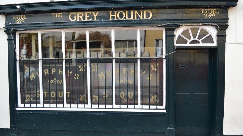 Exterior of The Grey Hound with Murphy's Stout advertisements in the windows