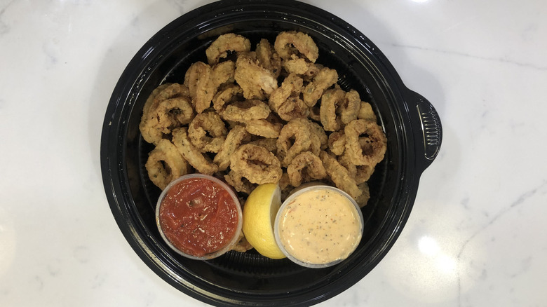 Olive Garden calamari appetizer with sauce in to-go container.