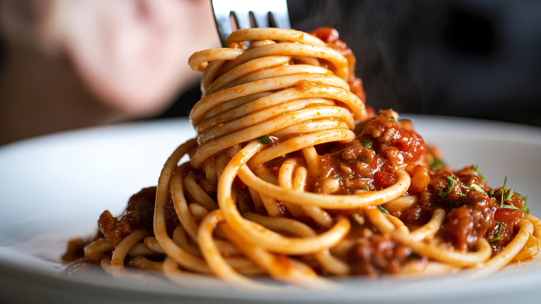 A fork twirling a bite of spaghetti with meat sauce