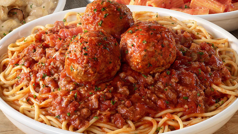 a bowl of Olive Garden's spaghetti with meat sauce with three meatballs in the center