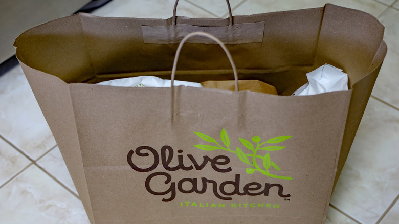 A bag of food from Olive Garden on a kitchen floor