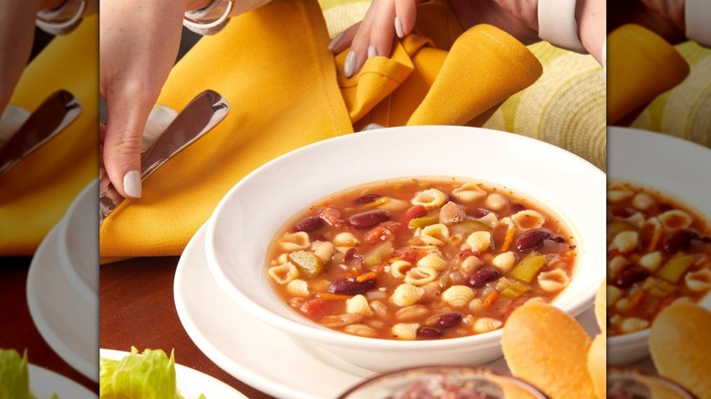 Olive Garden soup on the table with hands surrounded by a mirror border