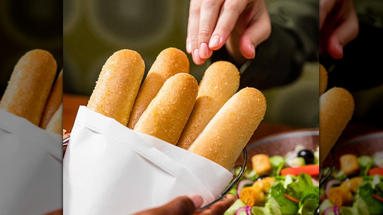hand reaching for breadsticks at Olive Garden, mirrored image