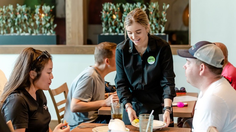 Olive Garden server helping customers