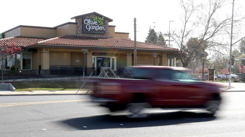 Car driving by an Olive Garden restaurant
