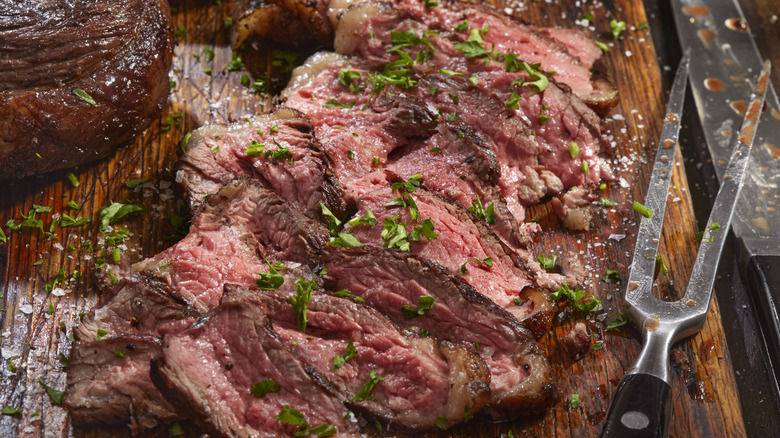 Close up of cooked sliced top sirloin on a wooden board