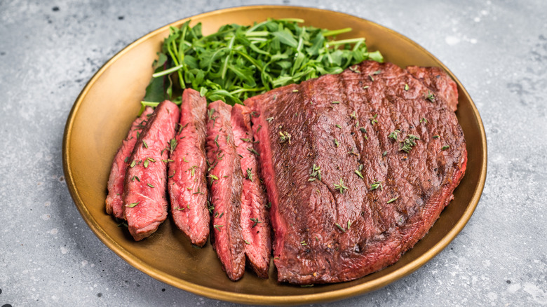 A top sirloin steak served with arugula