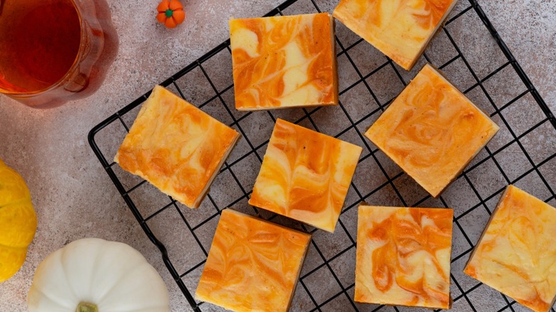 Marbled pumpkin cheesecake bars cooling on a wire rack
