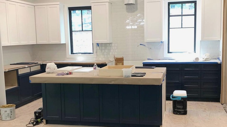 Kitchen being painted with white upper cabinets, navy lower cabinets.