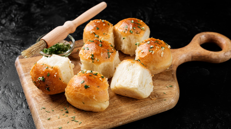 fresh rolls on wooden serving dish with garlic butter