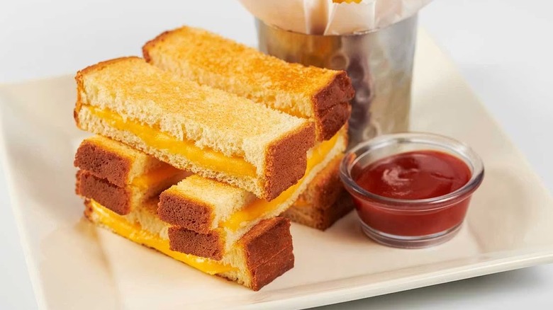 Stacked grilled cheese strips from The Cheesecake Factory on plate with ketchup.
