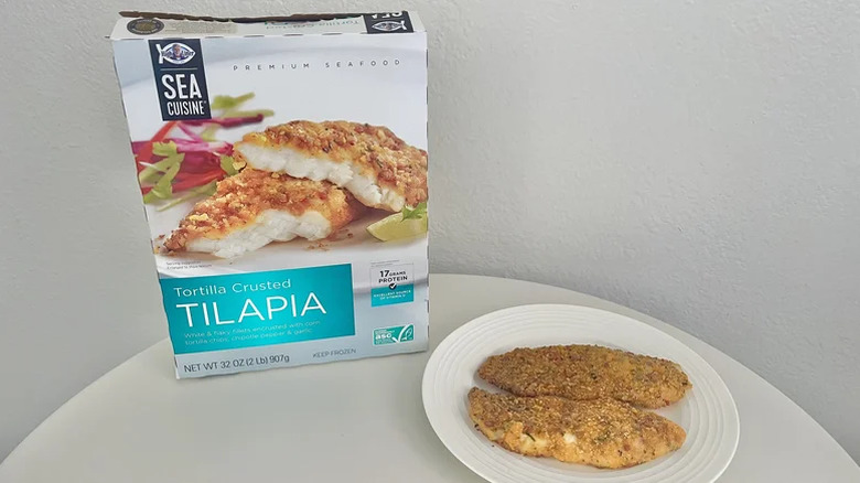 Two pieces of Sea Cuisine Tortilla Crusted Tilapia on a white plate next to the box