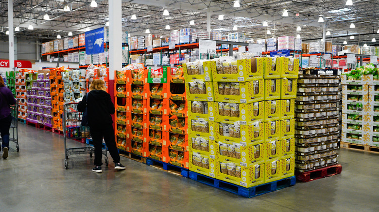 people pushing carts along Costco display of snacks