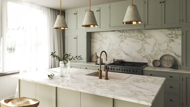 A modern kitchen featuring marble countertops and gray wall paint
