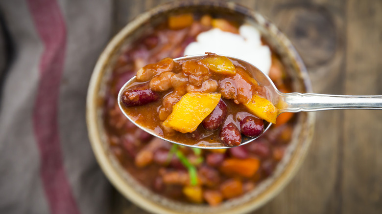 Overhead view of spoon and bowl of chili