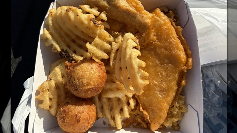 Long John Silver's basket with waffle fries, hushpuppies, fried fish, and a chicken tender