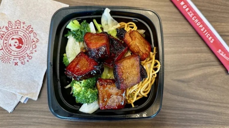 Panda Express' Cantonese Barbecue Brisket over greens and noodles in a takeout container