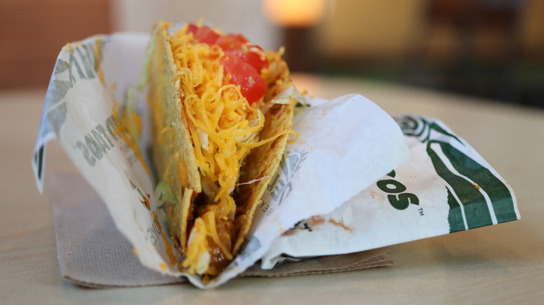 A close up of a Del Taco taco in wrapping.