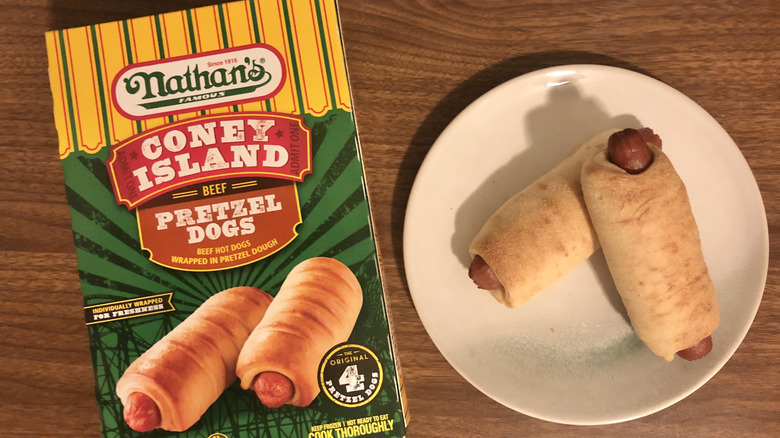 Package of Nathan's Famous Coney Island Beef Pretzel Dogs and 2 of the pretzel dogs on a white plate