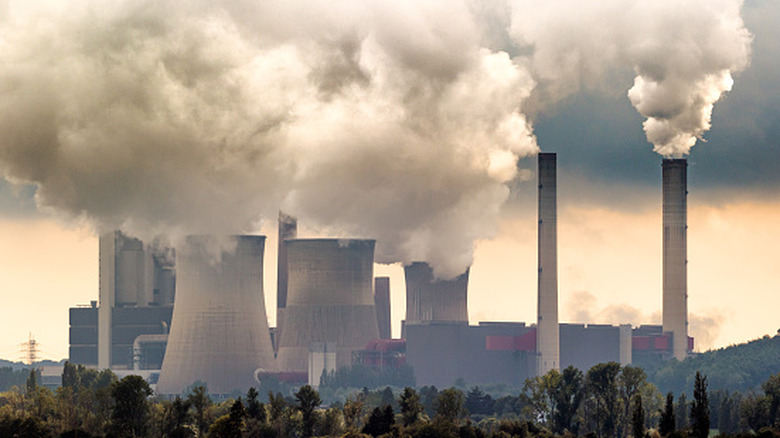 Great big grey and brown smoke enters the air from coal power plant stacks.