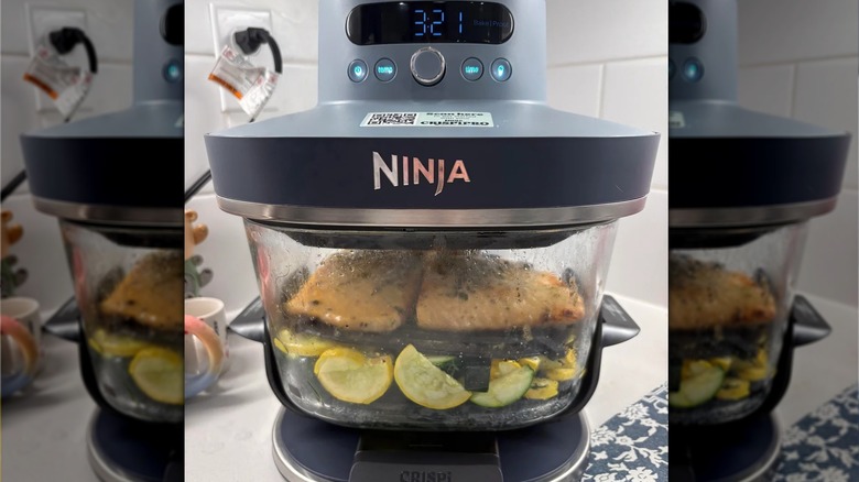 Ninja Crispi cooking chicken dish in glass basket