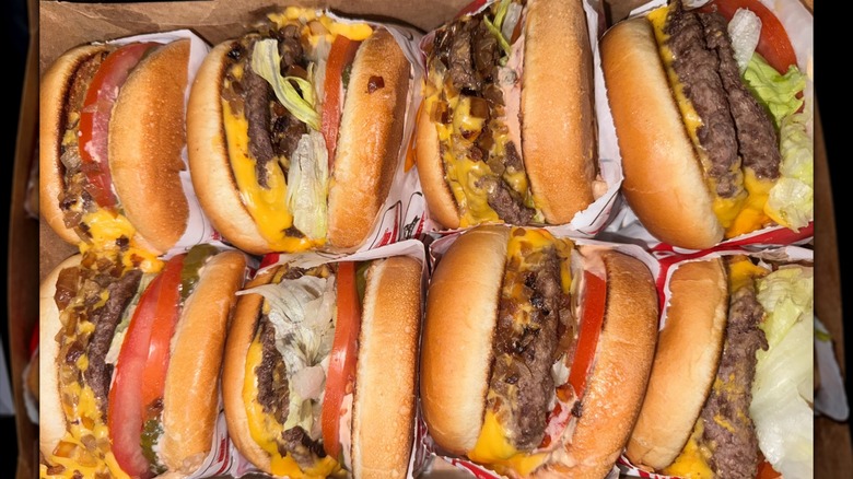 Eight In-N-Out burgers piled next to each other in a box